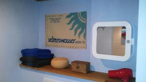 a shelf with a mirror and a sign on a wall at Ferienhaus Marktstraße in Tangermünde