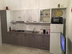 W kuchni znajduje się biała lodówka i kuchenka mikrofalowa. w obiekcie Casa Comasia w mieście Martina Franca