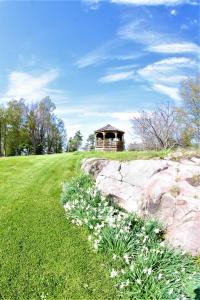 a grassy field with a gazebo in the distance with a path at The Ledges Resort & Marina in Alexandria Bay