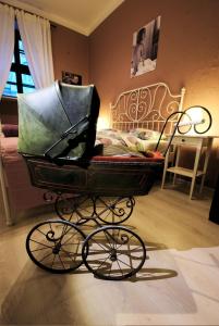 Un cochecito de bebé sentado en una habitación con cama en Rosemary's Private Ensuite Rooms in Old Town, en Poznan