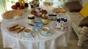 una mesa con comida para el desayuno y bebidas en ella en B&B Cadrecca Tra Terra Luna e Mare, en Licciana Nardi