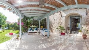 a patio with tables and chairs and a stone wall at Alura Hotel in Alacati