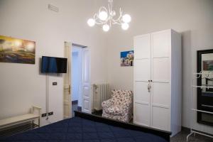 a bedroom with a bed and a chair and a chandelier at Da zia Concetta in Campi Salentina