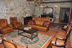 a living room with leather furniture and a table at Quinta de Albergaria in Facha