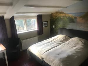 Schlafzimmer mit einem Bett mit Wandgemälde in der Unterkunft Beachroom in Zandvoort