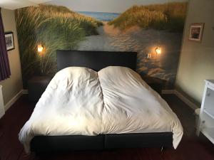 Schlafzimmer mit einem Bett mit Wandgemälde in der Unterkunft Beachroom in Zandvoort