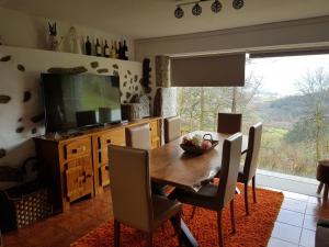 ein Esszimmer mit Tisch und Fernseher in der Unterkunft Quinta da Tormenta -14 pessoas- Cabeceiras de Basto 2 casas e piscina privada in Cabeceiras de Basto