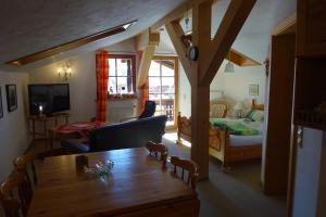 un soggiorno con tavolo e una camera da letto di Zum Alten Forsthaus a Reit im Winkl