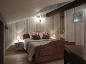 a bedroom with a bed with two tables and two lamps at Le Piquet in Fonsorbes