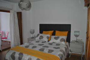 a bedroom with a bed with orange and gray pillows at Casa La Plaza in Frigiliana