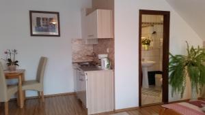 a small kitchen with a sink and a table at Majláth Vendégház in Bük +49 photos