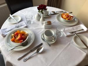 a white table with plates of fruit on it at The Windsor Carlton in Blackpool