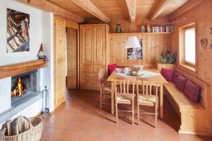 uma sala de jantar com uma mesa e uma lareira em Albergo Diffuso Sauris in Sauris Di Sopra em Sauris