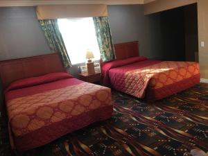 1 dormitorio con 2 camas y ventana en Budget Inn LAX-Lawndale en Lawndale