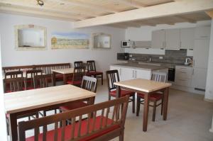 - une cuisine et une salle à manger avec des tables et des chaises en bois dans l'établissement Beim Schuster, à Pappenheim