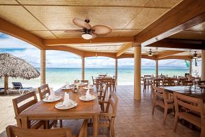 um restaurante na praia com mesas e cadeiras em Beach House Condos, Negril em Negril