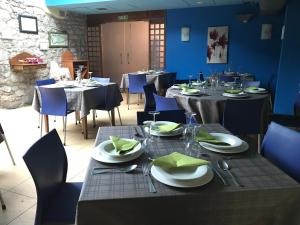 un comedor con mesas y sillas con platos y servilletas en Hotel Torrepalacio, en Proaza