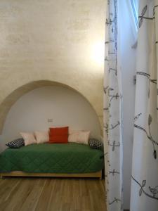 a room with a green bed in a building at Il Trifoglio in Matera