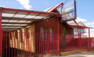 un bâtiment rouge avec un panneau devant lui dans l'établissement Hostal Maria, à Castro