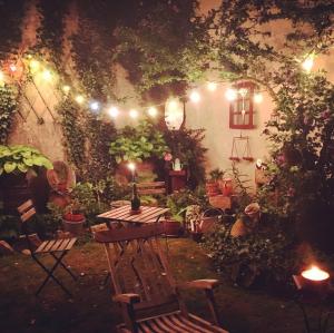 a garden with a table and chairs and lights at Villa Vero in Contrexéville