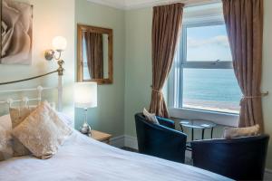 a bedroom with a bed and a window with the ocean at The Grafton Guest House in Llandudno
