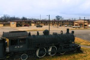an old train on display in a parking lot at Regal Inn Coffeyville in Coffeyville