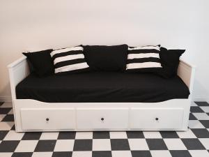 a white bed with black sheets on a checkered floor at Il Capitano in Lerici