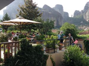 a group of people at a restaurant with mountains in the background at Hotel Doupiani House in Kalabaka