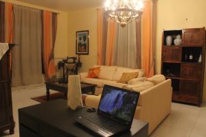 a living room with a couch and a laptop on a table at La casa di Bia in Corleone