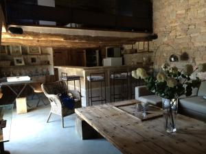 a living room with a wooden table with a vase of flowers at La Maison Du Meunier in Loze