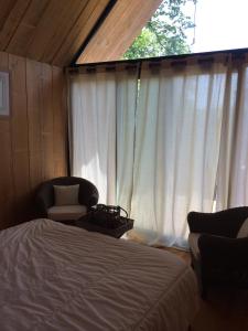 a bedroom with a bed and two chairs and a window at La Maison Du Meunier in Loze
