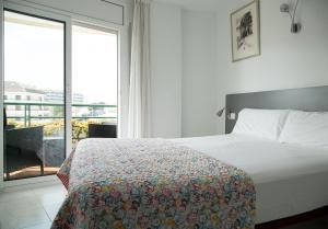 1 dormitorio con cama y ventana grande en Apartaments Plus Costa Brava Estartit, en L'Estartit