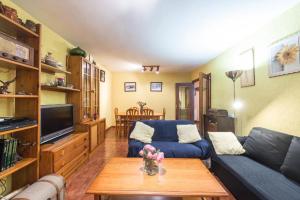 マドリードにあるVivienda Familiar con Jardin junto a Ifemaの青いソファとテーブルのあるリビングルーム