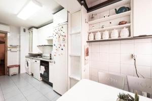 a kitchen with a white refrigerator and a stove at Vivienda Familiar con Jardin junto a Ifema in Madrid