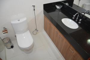 a bathroom with a toilet and a sink at Hotel Cosini in São Sebastião do Paraíso