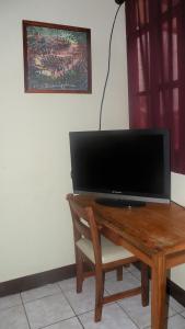 a wooden table with a television on top of it at AC Room 2 Persons Hospedaje Don Wilfredo in San Juan del Sur