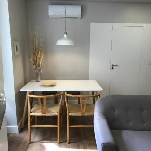 uma mesa e cadeiras numa sala de estar com um sofá em Welcome inn Viseu em Viseu