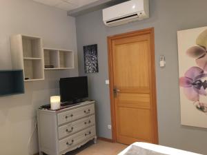 a bedroom with a dresser with a television and a door at Sainte Maxime Studio 2 in Sainte-Maxime