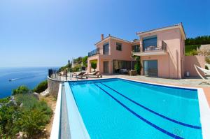a villa with a swimming pool overlooking the ocean at Villa Alkionis in Skala Kefalonias