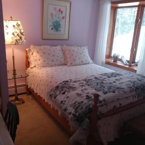 a bedroom with a bed and a lamp and a window at Cricket Hill in Killington