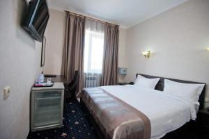 a hotel room with a bed and a television at Business Hotel Europa in Khabarovsk