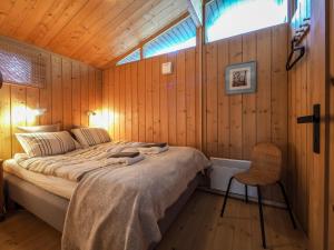 a bedroom with a bed in a wooden wall at Lovely Cabin in the Capital Area with hot tube in Hafnarfjördur