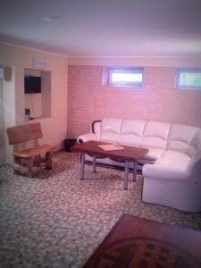 ein Wohnzimmer mit einem weißen Sofa und einem Tisch in der Unterkunft Marijonu Apartments in Panevėžys