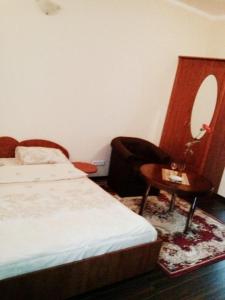 a bedroom with a bed and a table and a chair at Marijonu Apartments in Panevėžys