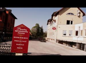 a red sign sitting in front of a building at Marijonu Apartments in Panevėžys