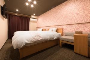 um quarto com uma cama grande e uma cadeira em Stay SAKURA Kyoto Nijo Seasons em Quioto