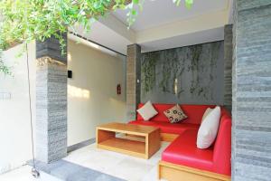 sala de estar con sofá rojo y mesa en Seminyak Villa, en Seminyak