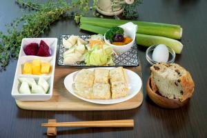 a table with a plate of bread and fruits and vegetables at Beauty Spring N Harvest Guest House in Puli