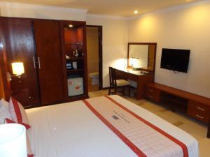 a bedroom with a bed and a desk and a television at Petro House Vung Tau - Block B in Vung Tau