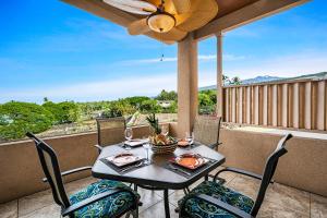 - Balcón con mesa y sillas y ventilador de techo en Beach Villas Kahaluu on Kona Coast en Kailua-Kona